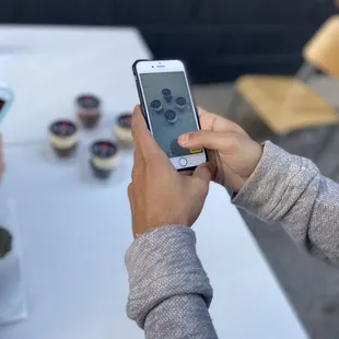 a person taking a picture of a cupcake