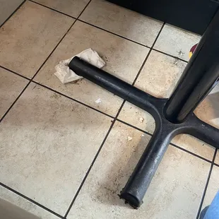 Under one side of a table.