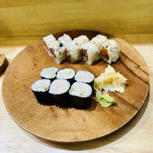 a wooden plate with sushi on it