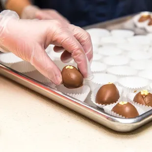 a person placing chocolates on a tray