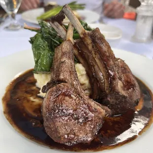 a plate of lamb chops and mashed potatoes