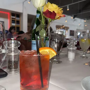 a glass of red wine with a flower in it