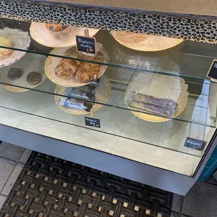 a display of pastries in a glass case