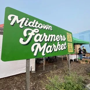 a large green sign for midtown farmers market