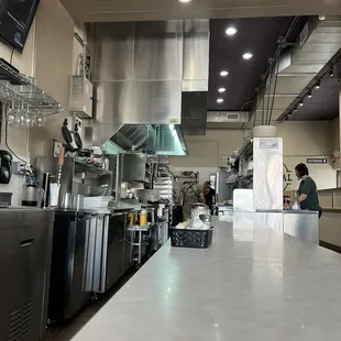 Counter seating view of the cooks. Waiting on my lunch to go.