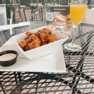 a plate of chicken wings and a glass of orange juice