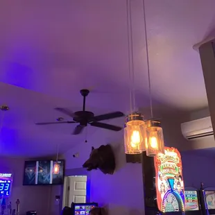 a bar with a ceiling fan and neon lights