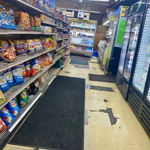 Aisle inside.  Floor mats cover uneven, broken flooring.