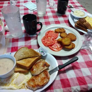 2 Egg and Tenderloin Breakfast, Toast, Gravy with sides of Potato Cakes and Tomatoes. Veggie Omelet with Grits and Wheat Toast