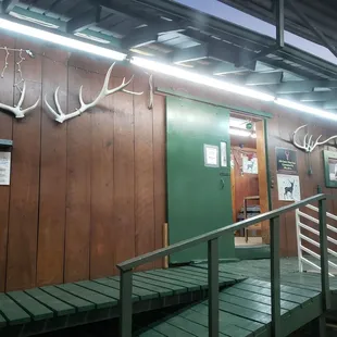 a wooden building with antlers on the wall