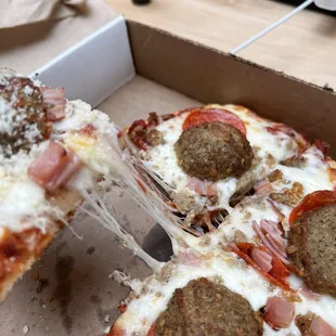a slice being taken out of a pizza box