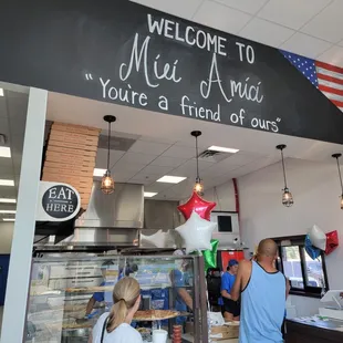a sign that reads welcome to miei amici pizzeria you&apos;re a friend of