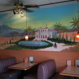 a mural of a house and palm trees