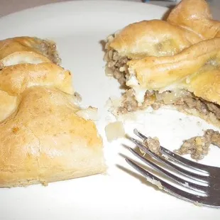 a half eaten sandwich on a plate with a fork