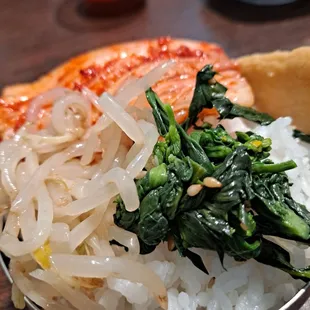 a bowl of food with onions and spinach