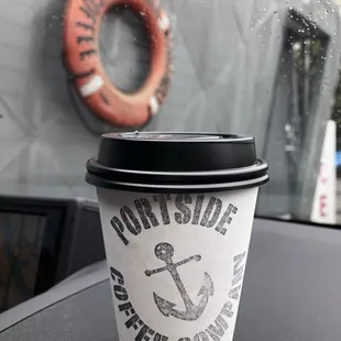 a coffee cup with a life preserver in the background