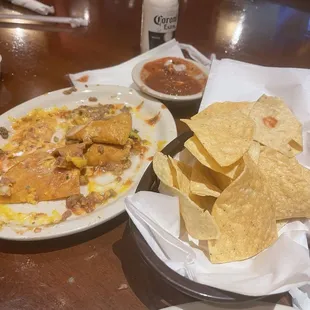 A basket of chips and some of the nachos.