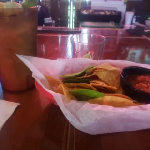 a bowl of chips and a drink