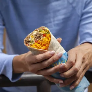 a person holding a burrito