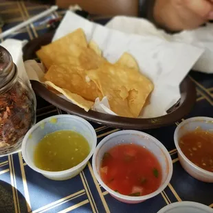 Fresh tostadas with sides of tomatillo salsa, original salsa, pico de gallon, and chile del arbol.