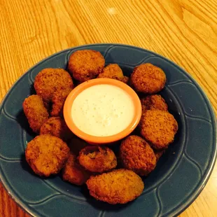 a plate of fried tater tots with dip