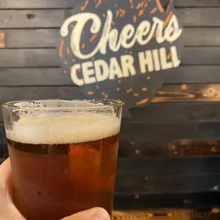 a hand holding a glass of beer