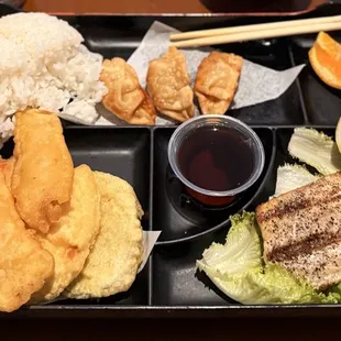 Bento meal set with Tempura Shrimp &amp; Vegetables, Saba Shioyaki, Rice, Pot Stickers, sauce and garnish.