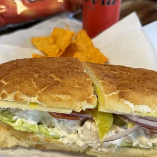 Chicken salad sandwich on Dutch crunch with everything, side of chips and soda.