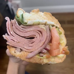 a person holding a sandwich