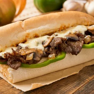 a steak sandwich with peppers and onions