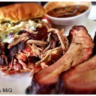 Pulled pork sandwich with a few ribs on the side.