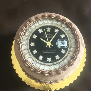 Chocolate ice cream cake frosted with chocolate whipped cream icing and topped with Rolex diamond watch edible image