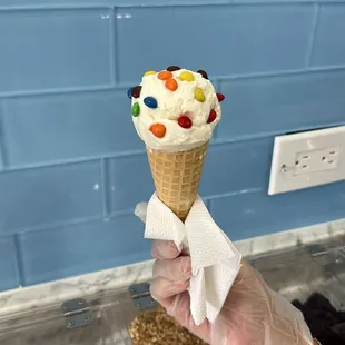 a hand holding an ice cream cone