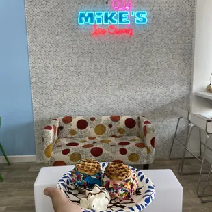 a hand holding a plate of waffles