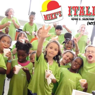 a group of children in green shirts