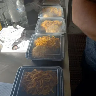a row of plastic containers of spaghetti