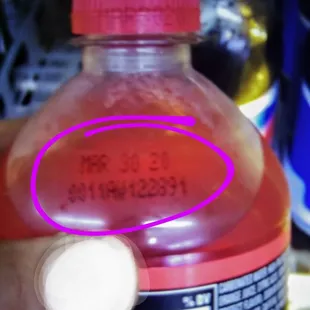 a hand holding a bottle of soda