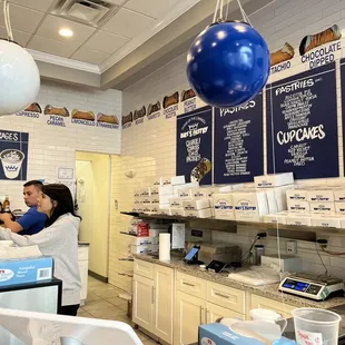 Flavors of cannolis on the wall behind the counter