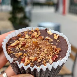 a hand holding a chocolate cupcake