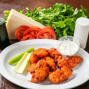 a plate of chicken wings and vegetables