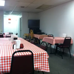 a dining room with red and white checkered tablecloths