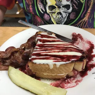 a sandwich with bacon and a pickle