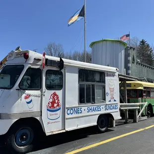 a white food truck parked in front of a water tower