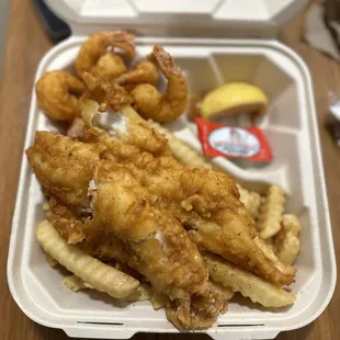 fried fish and fries in a styrofoam container