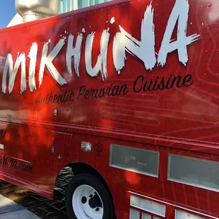 a red food truck parked on the side of the road