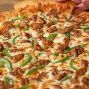 a person taking a slice of pizza