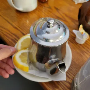 a person holding a teapot on a plate