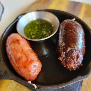 two sausages in a cast iron skillet