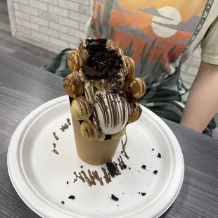 a chocolate covered cone with a chocolate drizzle on top
