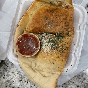 a piece of pizza in a styrofoam container